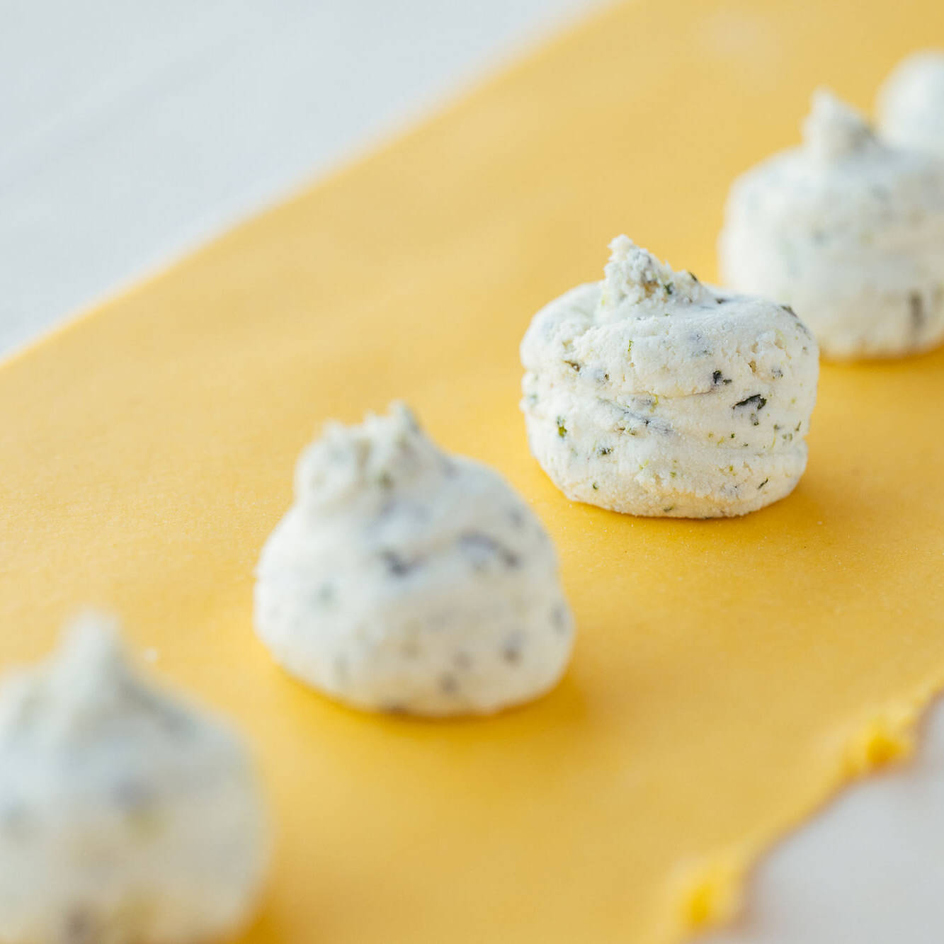 ripieno dei tortelli d'erbetta sulla pasta tirata in fase di realizzazione