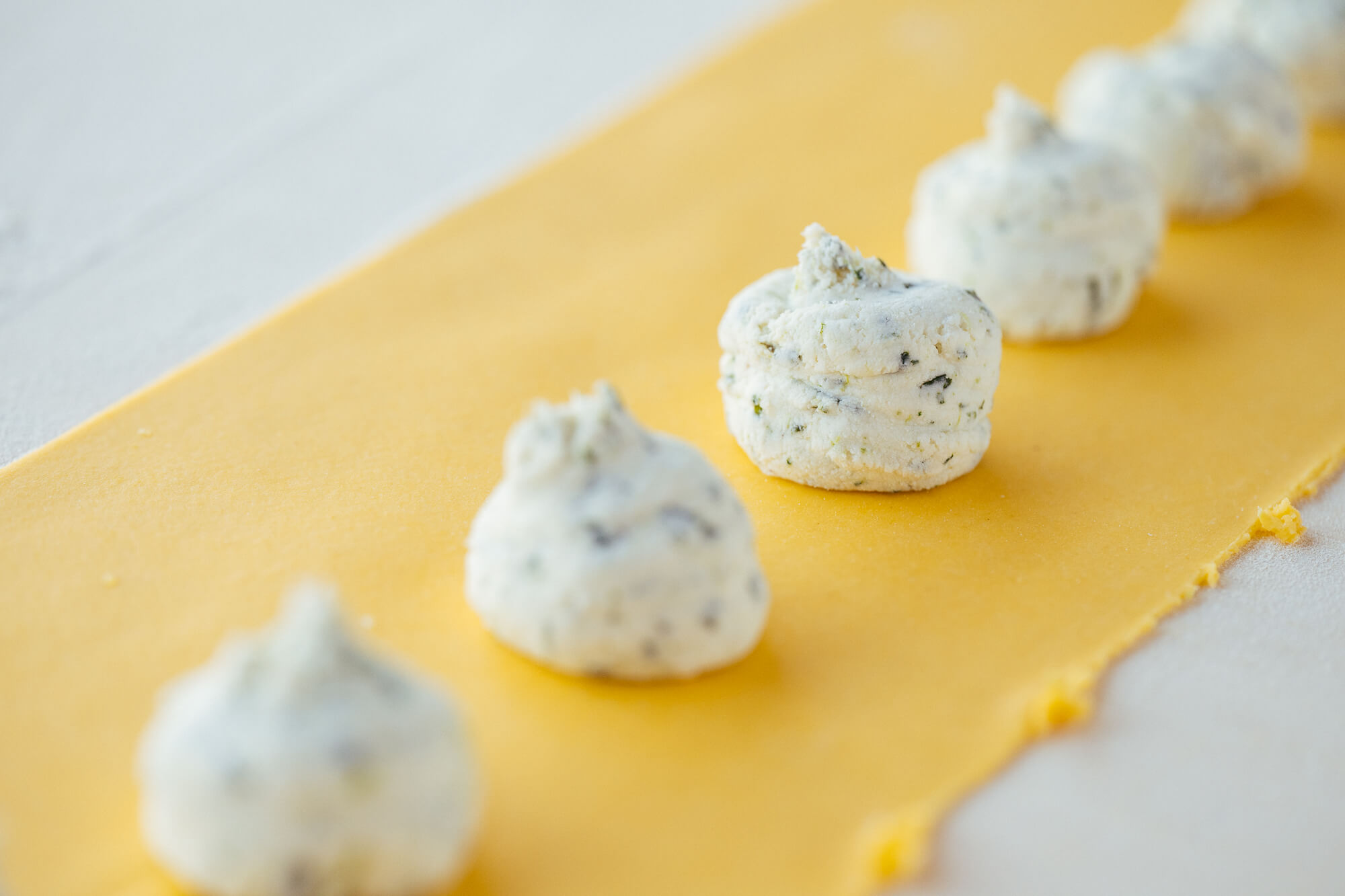ripieno dei tortelli d'erbetta sulla pasta tirata in fase di realizzazione